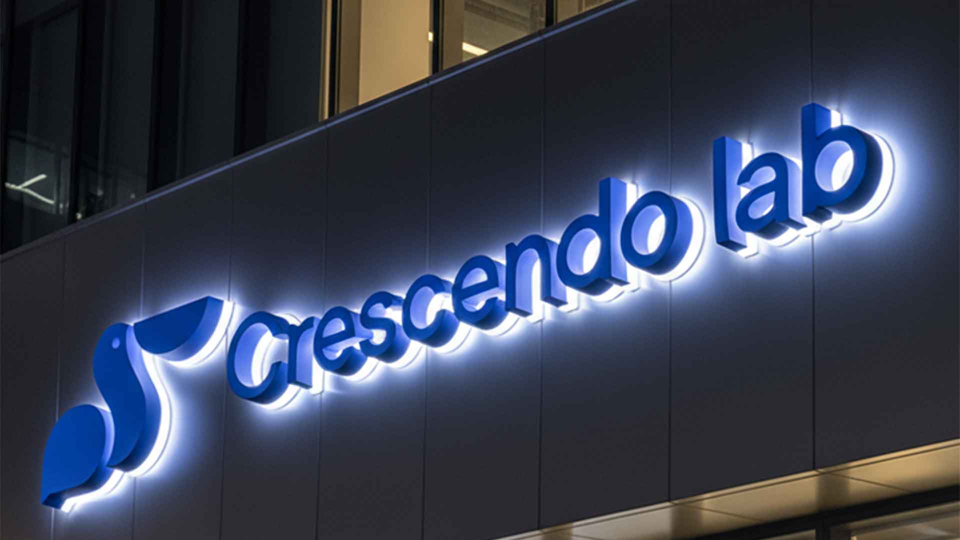 High-quality blue halo-lit backlit metal sign letters 'Crescendo lab' installed on a modern commercial building facade.