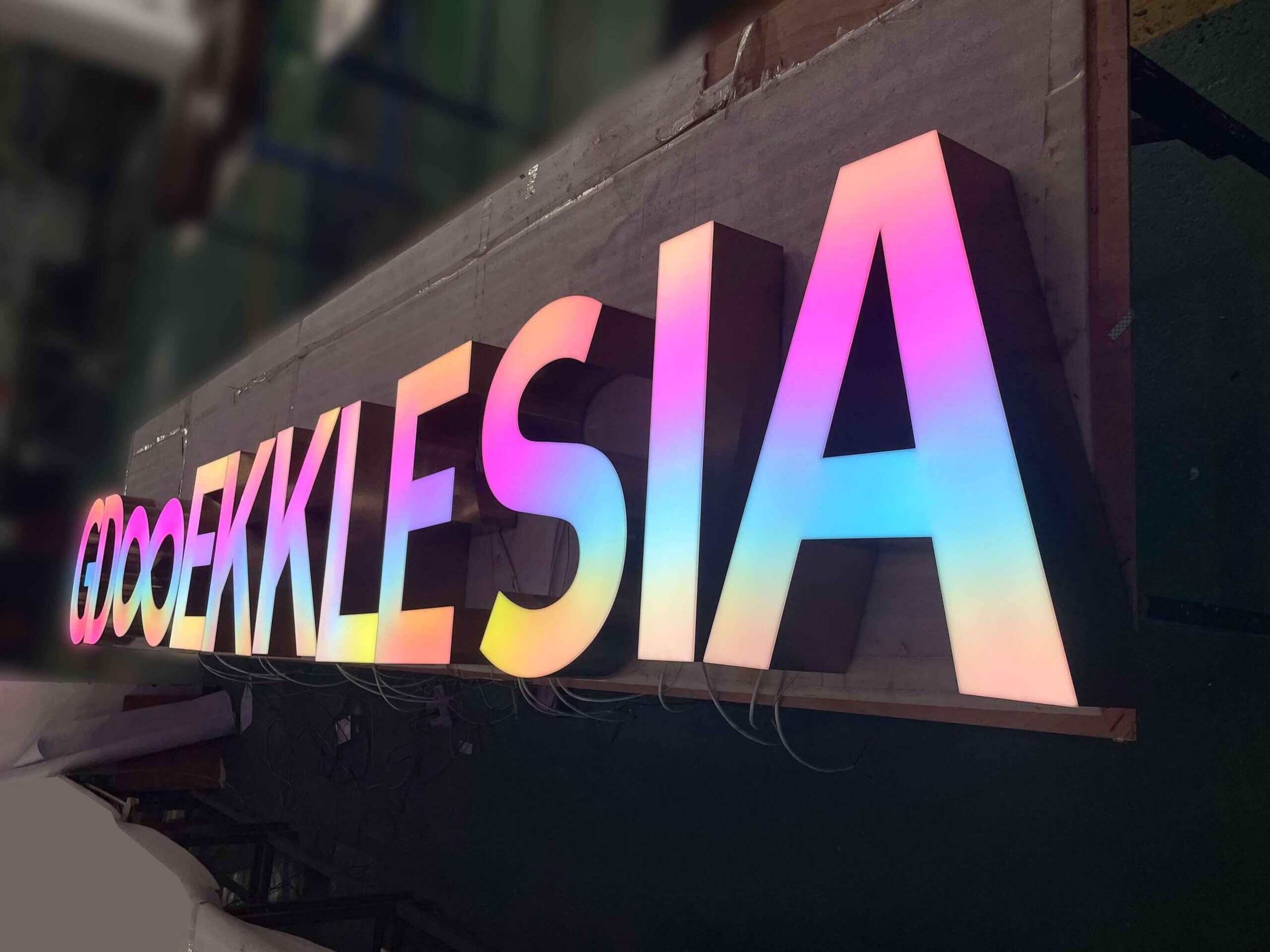 Factory testing of large RGB channel letters with vibrant gradient LED lighting for commercial storefronts