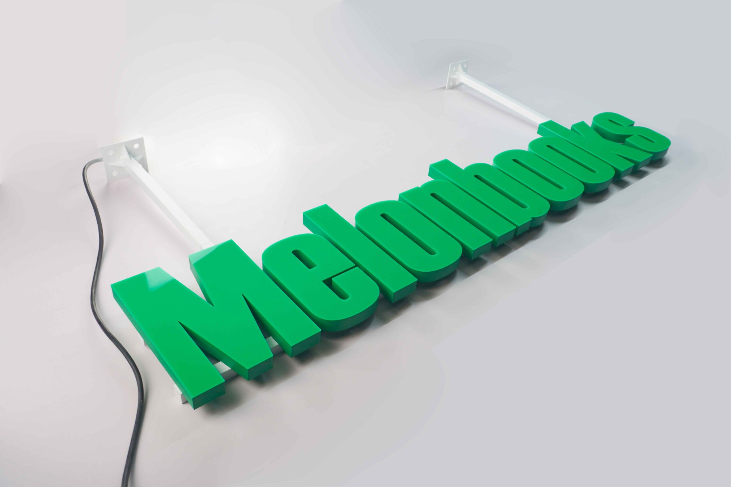 MAJI TREATS trimless hanging sign with silver metallic 3D letters, a modern minimalist suspended signage system.