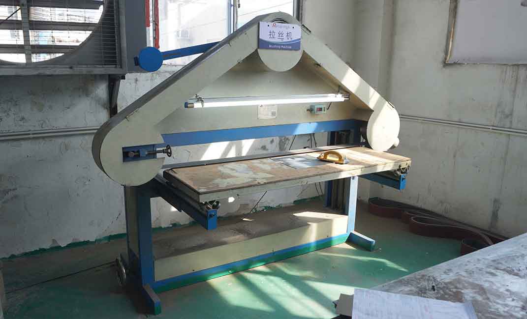 Professional industrial-grade stainless steel brushing machine used for fine texture processing on metal signage surfaces to ensure a uniform brushed finish.