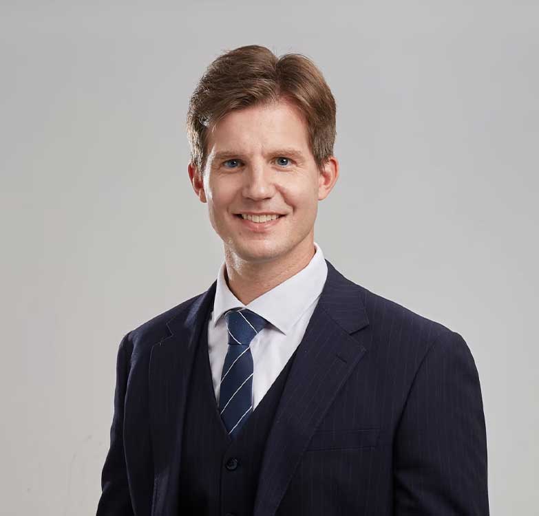 Retay·sign engineers and consultants discussing custom LED signage technical drawings and metal material samples with a client in a professional workshop setting.