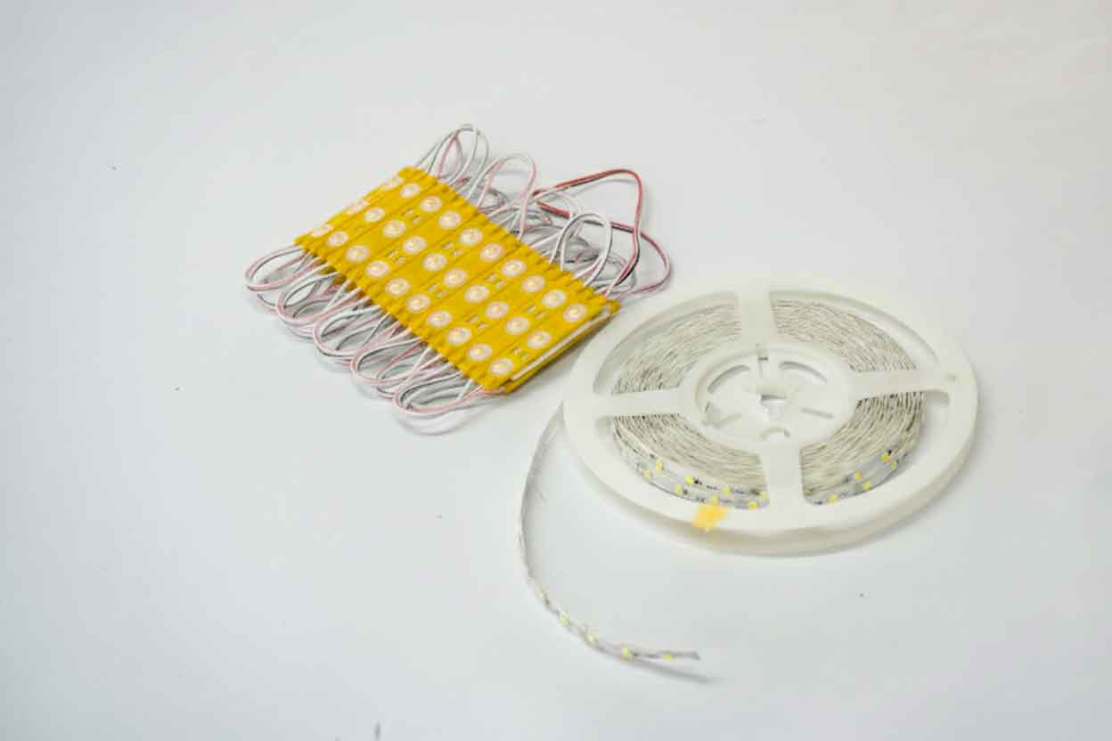 A display of high-brightness LED modules and a flexible LED strip reel, the core lighting components for achieving ultra-uniform illumination in signage.