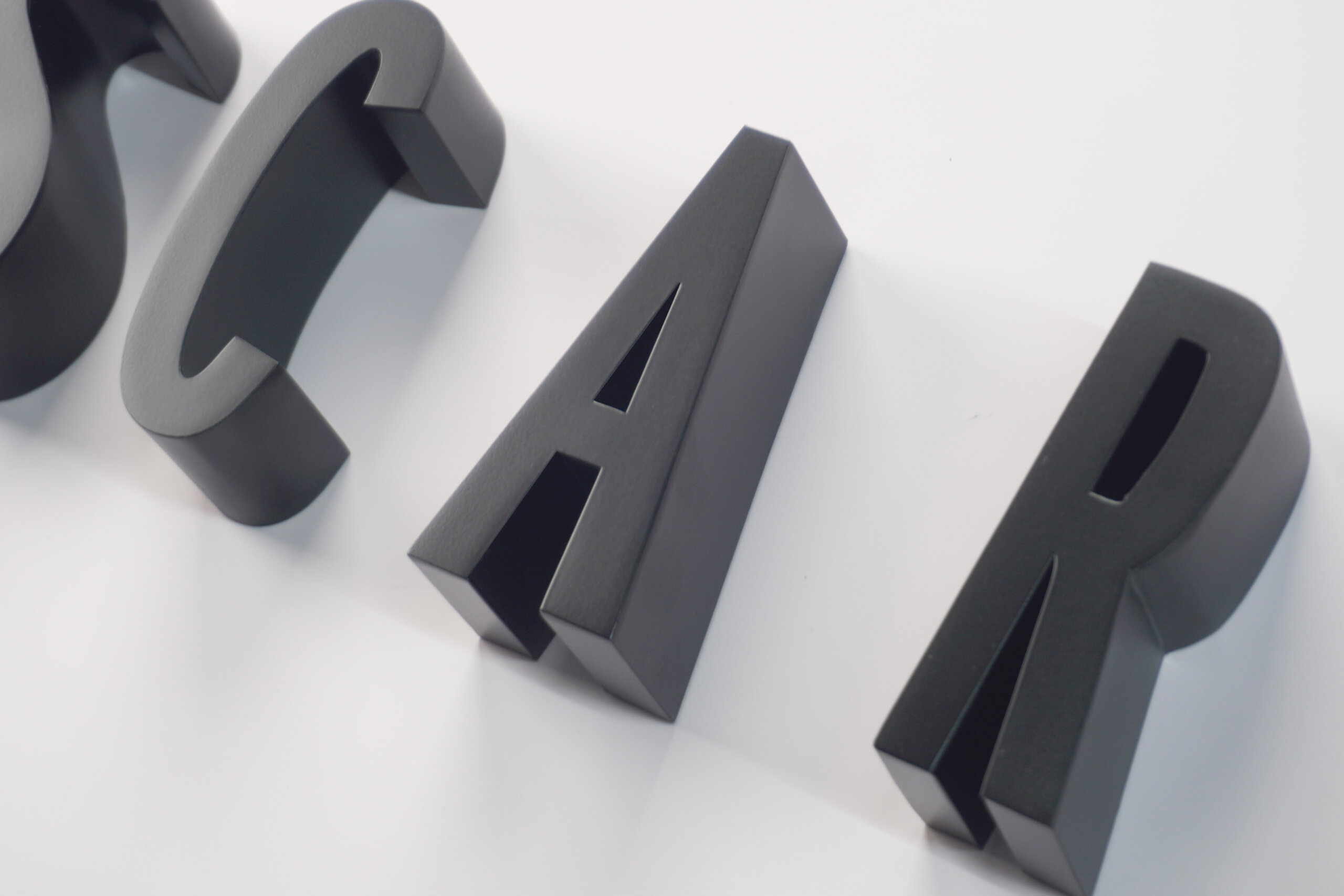 3D metal letters featuring a premium matte black finish and precision welding, showcasing sophisticated baked paint craftsmanship for high-end retail brand signage.