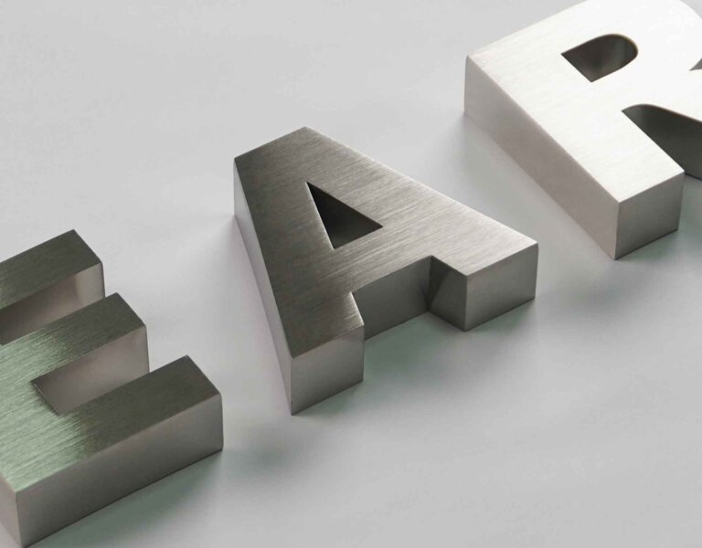 Showcasing 3D metal letters with a fine brushed stainless steel texture, featuring a silky metallic luster and high-precision cutting and polishing craftsmanship.