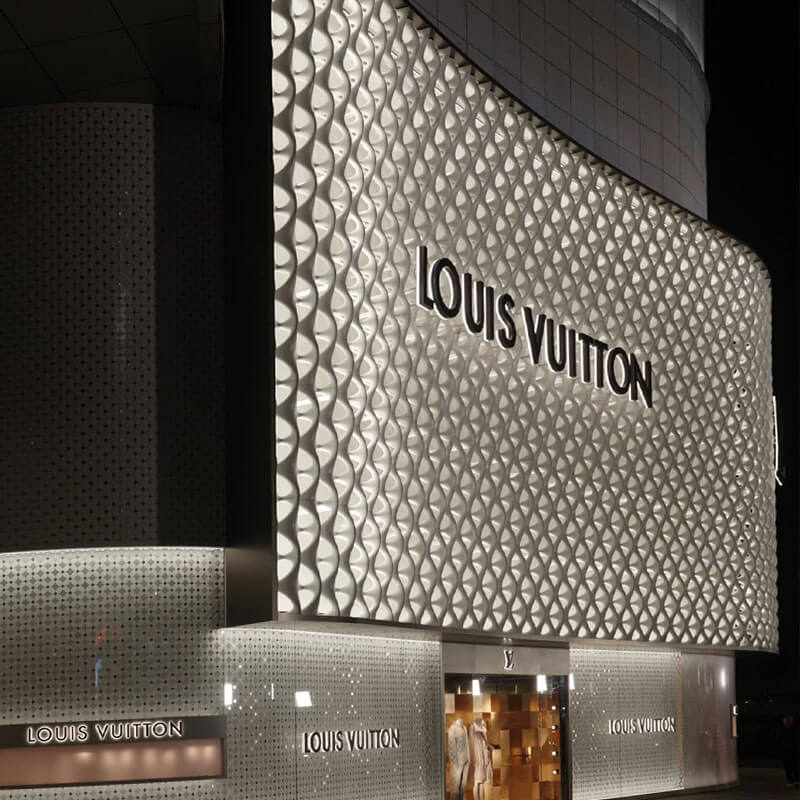 Illuminated yellow McDonald's brand signage installed on top of a modern glass-facade office building.