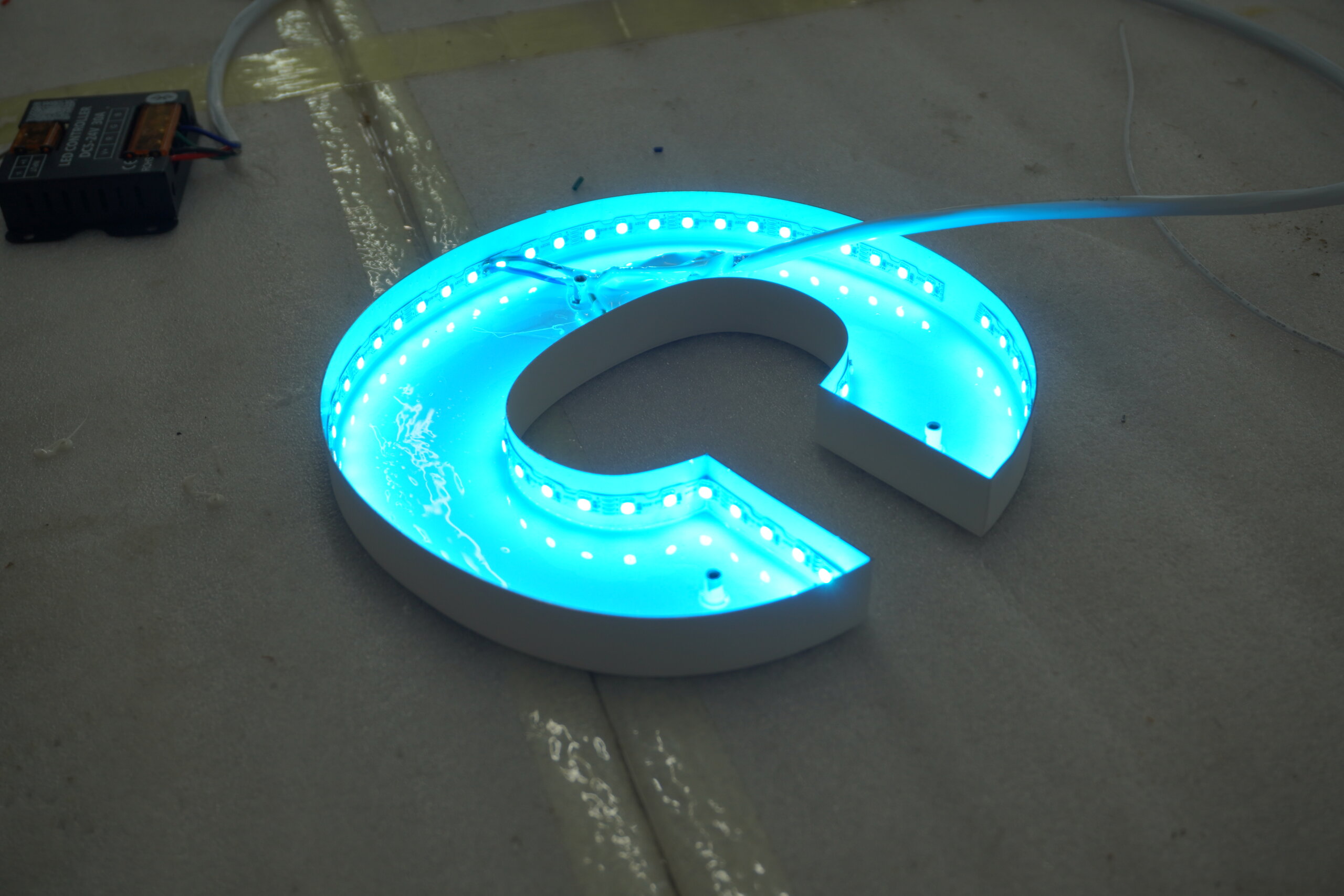 Round double-sided outdoor projecting light box for Saisons Restaurant, featuring custom printed logo and internal LED lighting.