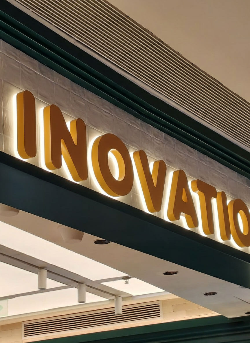 Close-up of yellow 3D backlit channel letters with a soft white glow, creating an elegant halo-lit silhouette.