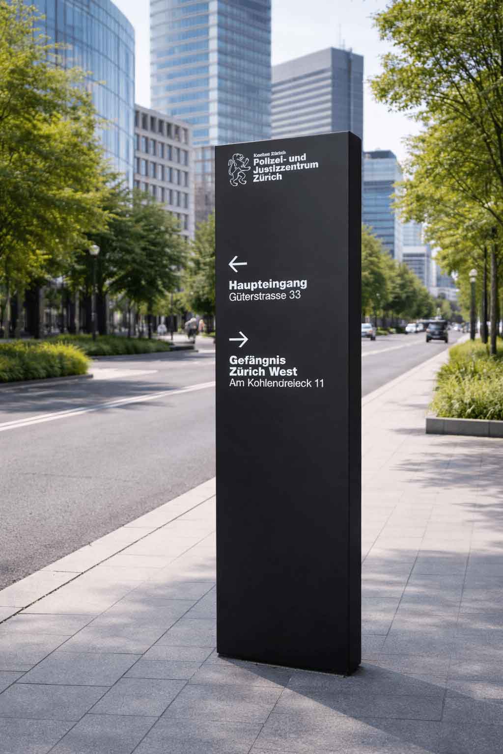A tall black outdoor pylon sign with white text and arrows on a city sidewalk, with modern office buildings in the background.