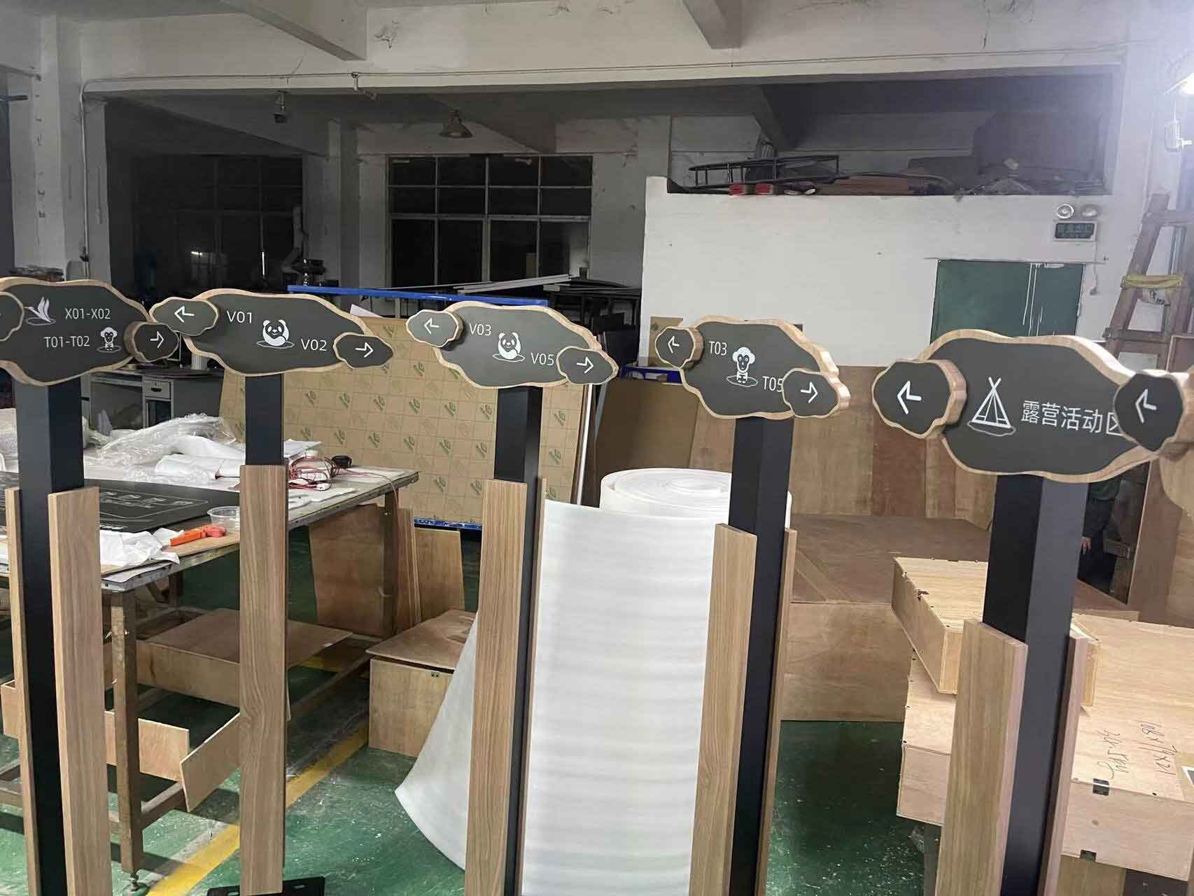 Elegant floor-standing wayfinding pylon in The Dubai Mall, featuring high-contrast bilingual directions and premium metallic finish for luxury retail environments.