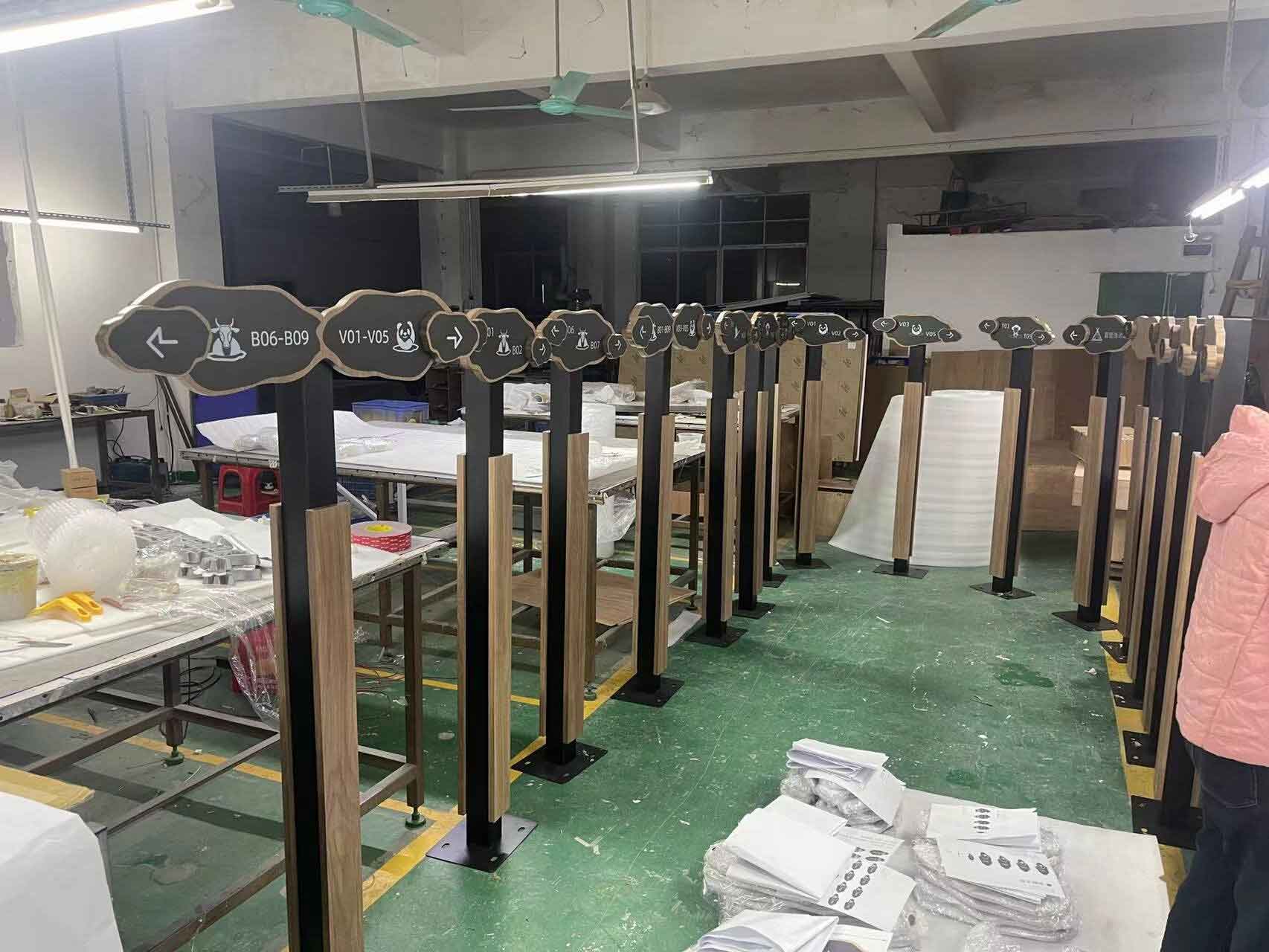 Elegant floor-standing wayfinding pylon in The Dubai Mall, featuring high-contrast bilingual directions and premium metallic finish for luxury retail environments.