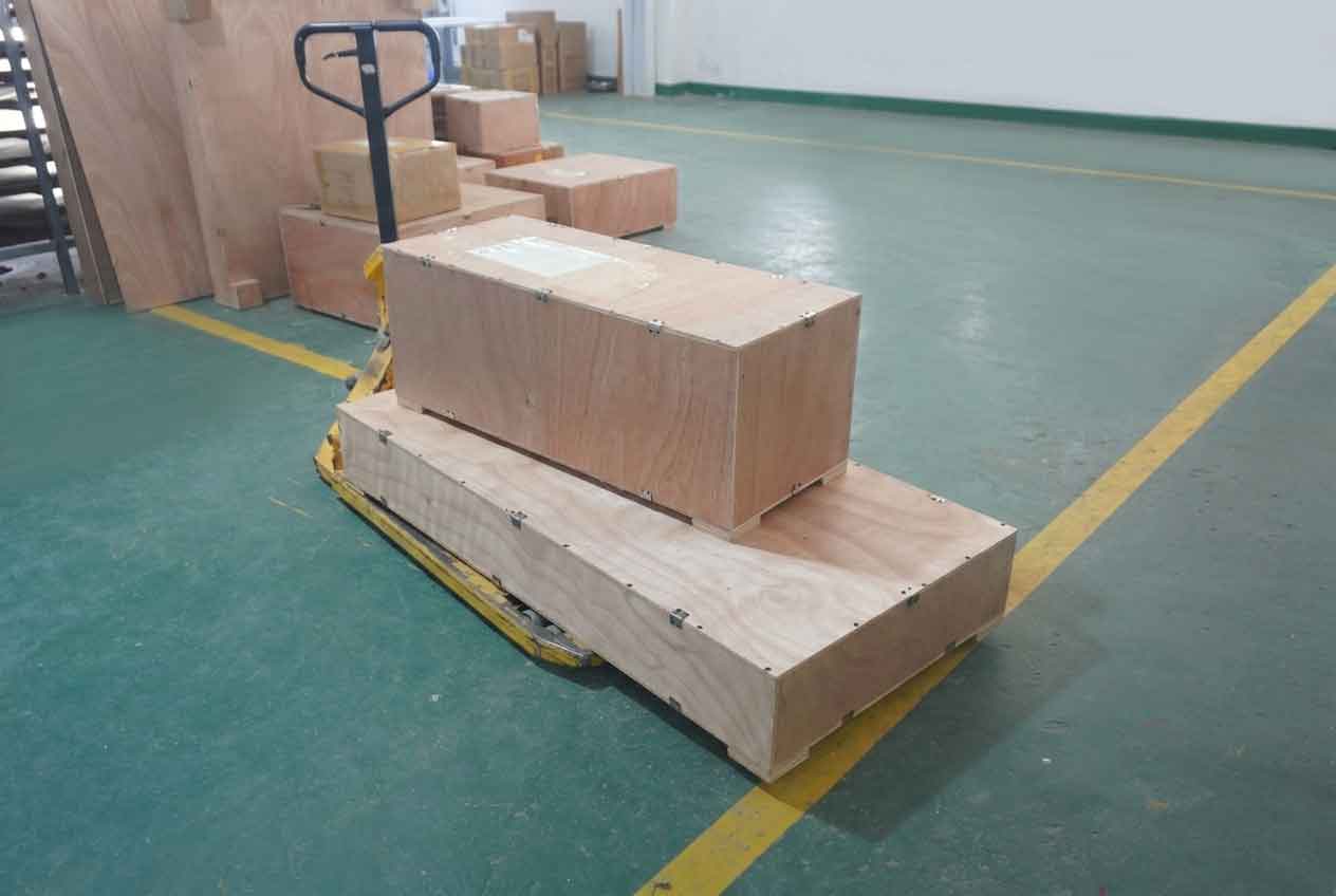 Capabilities 20 Reinforced wooden crates on a manual pallet jack in a warehouse, demonstrating secure industrial logistics packaging.