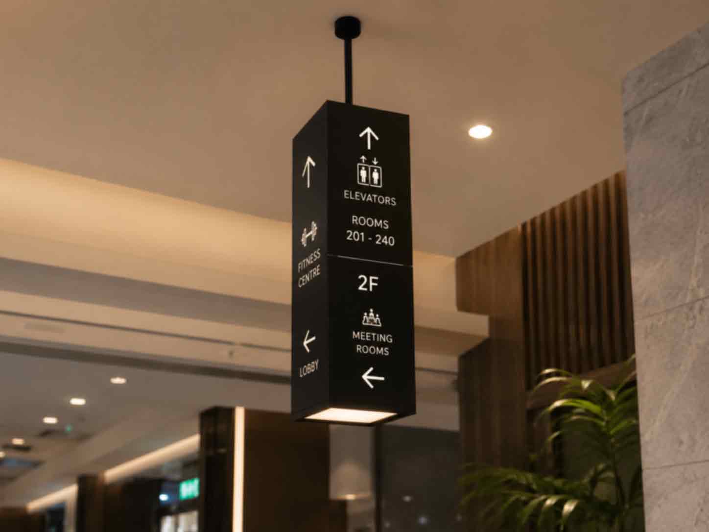 Commercial Light Box Signs 14 A minimalist light grey stone pylon sign next to a staircase. It features an up arrow for "Lift", "Restrooms", and "Rooms 101-107", and a right arrow for "Stairs to Meeting Rooms" and "Rooms 201-223", set against colorful terrazzo stairs.